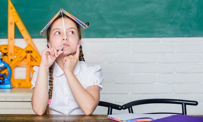 Una nia piensa en el aula