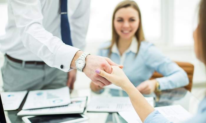 Un gerente da la mano a un cliente o un empleado