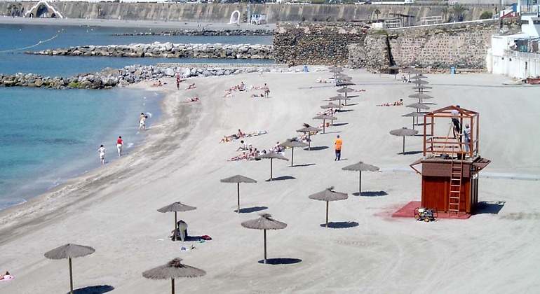 Playa con sombrillas y un puesto de socorrismo