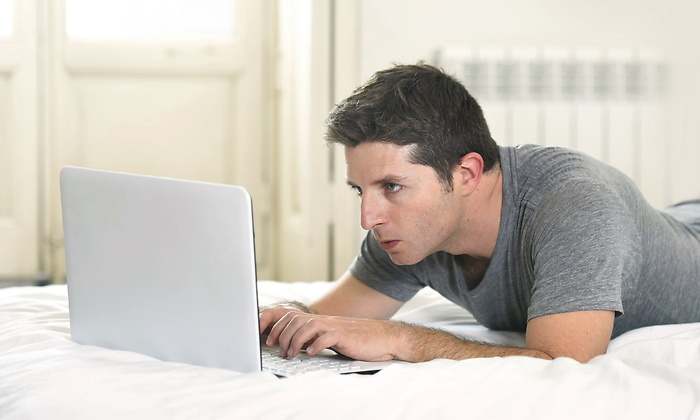 hombre-tramite-ordenador-tumbado-dreamstime.jpg