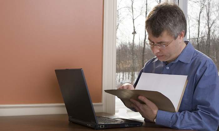 trabajador-consulta-documento-ordenador-dreamstime.jpg