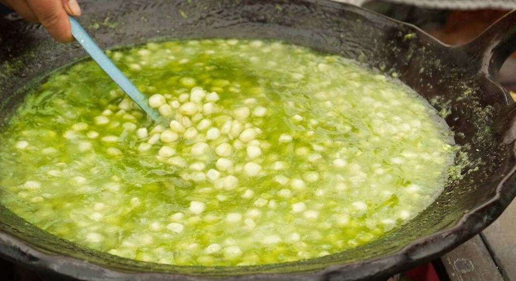 Esquites en una olla de barro, con condimento de epazote