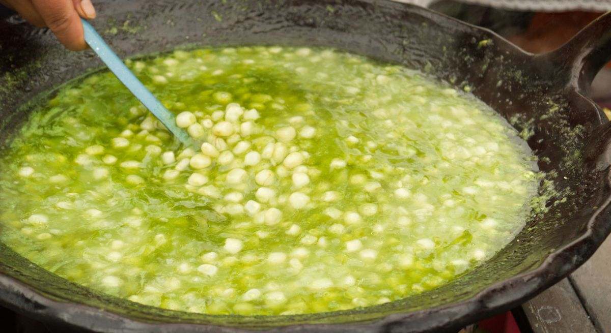 Esquites en una olla de barro, con condimento de epazote
