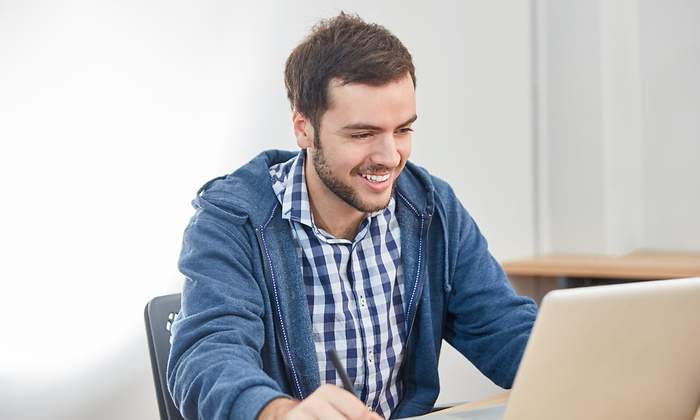 hombre-sonrie-tramite-ordenador-dreamstime.jpg