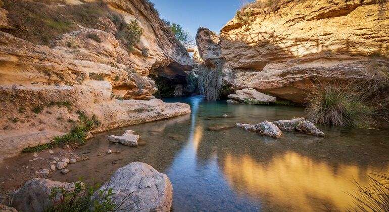 Cascada llamada Salto del Usero en Bullas, Murcia, España. Aguas azules y cristalinas bajo una cueva de roca amarilla - Foto de stock