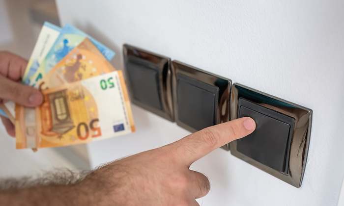 interruptor-luz-mano-senala-billetes-dreamstime.jpg