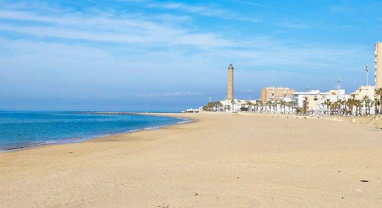 Extenso arenal con el faro al fondo