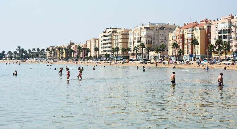Una playa en la que hay bañistas en el agua