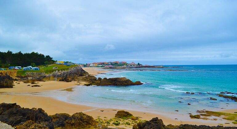zona de playa con rocas y caravanas a lo lejos