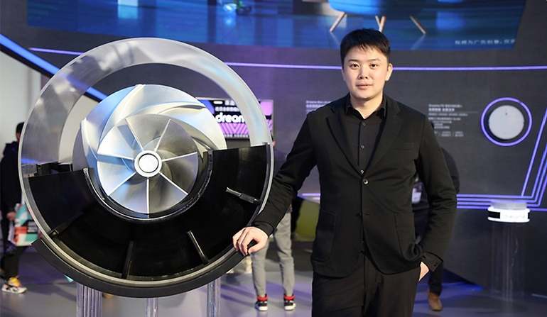 Yu Hao, fundador de Dreame, junto a un modelo de las máquinas rotativas creadas por él