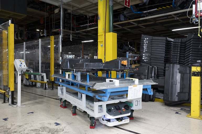 Carros autónomos se mueven por toda la planta, en este caso transportando una batería completa (el elemento de color negro en la parte más alta del carro)