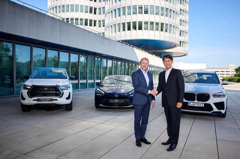 Los máximos responsables de BMW y Toyota en la sede de la primera en Munich, delante de dos prototipos de pila de combustible y del modelo de serie Toyota Mirai