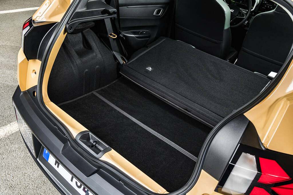 Dacia Spring 2024. Volumen de carga de 308 litros (un 6% más respecto al modelo anterior), que alcanzan los 1004 litros con los asientos traseros abatidos. Dacia consigue aumentar el espacio eliminando la rueda de repuesto (en su lugar hay un kit de reparación de pinchazos) y reduciendo el grosor de las paredes (ha ganado 2 centímetros a lo ancho).