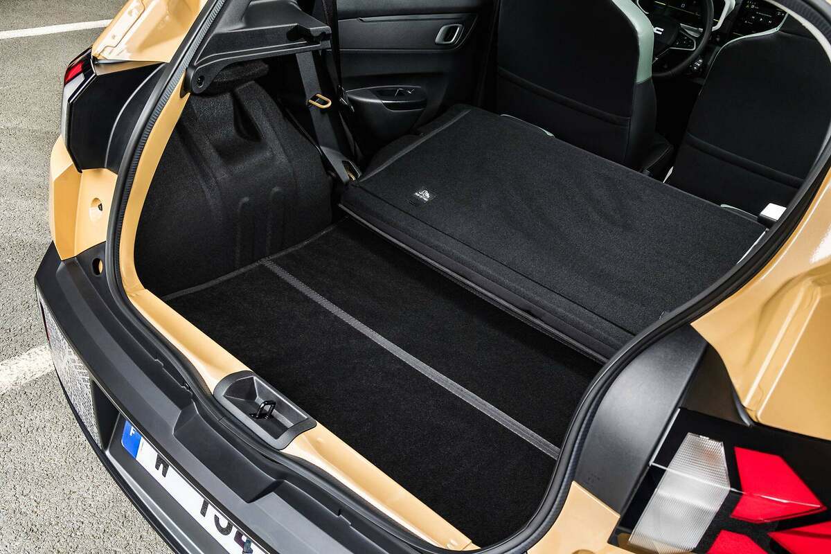 Dacia Spring 2024. Volumen de carga de 308 litros (un 6% más respecto al modelo anterior), que alcanzan los 1004 litros con los asientos traseros abatidos. Dacia consigue aumentar el espacio eliminando la rueda de repuesto (en su lugar hay un kit de reparación de pinchazos) y reduciendo el grosor de las paredes (ha ganado 2 centímetros a lo ancho).
