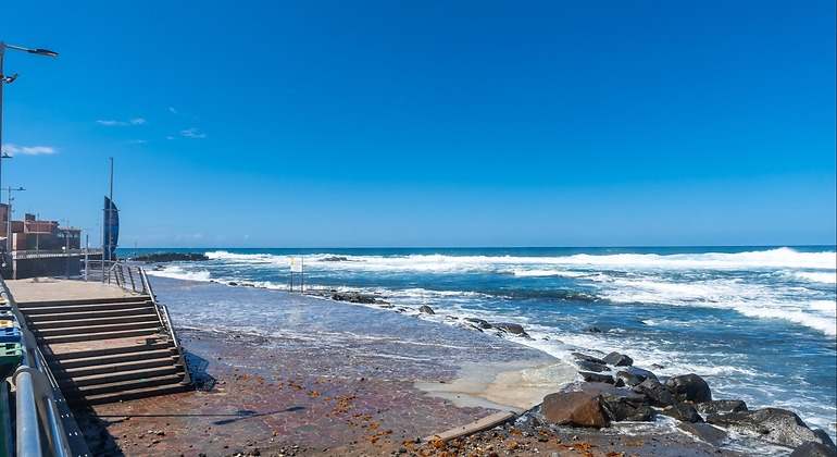 Piscinas naturales en Los Charcones y Playa el Puertillo y en Gran Canaria. Una escalera de metal baja hasta la playa