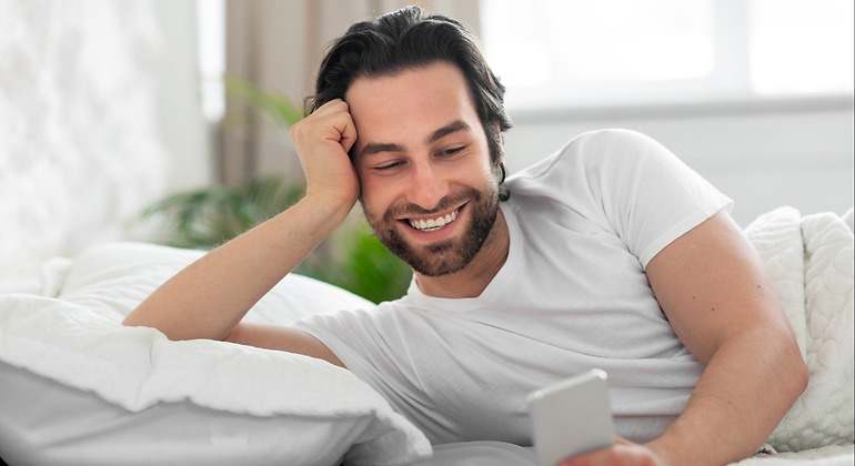Hombre con el móvil en la cama