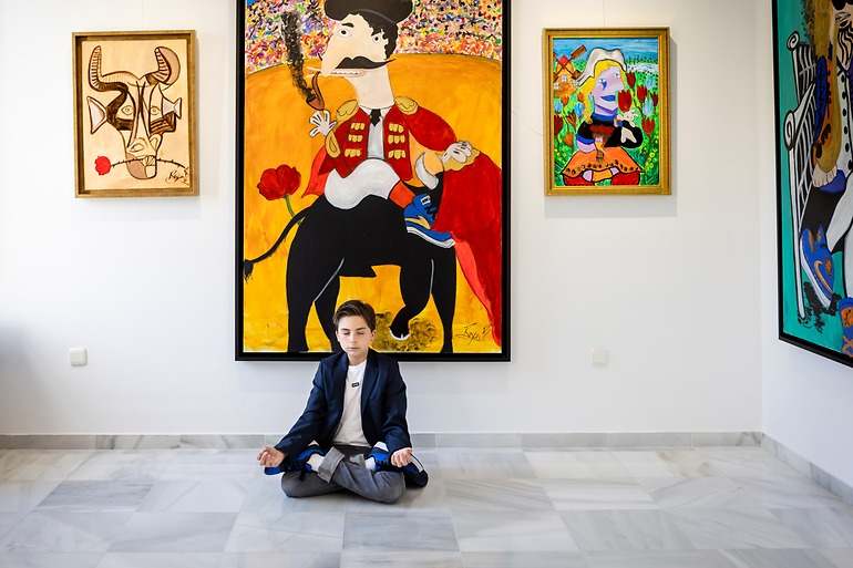 El joven artista con algunos de sus cuadros.