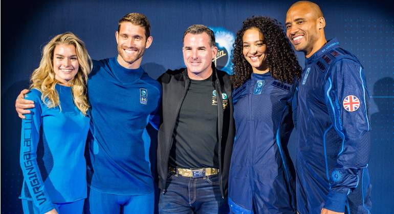 El fundador de Under Armour, Kevin Plank, está de pie con modelos que usan la capa base y el traje espacial diseñados por la UA.