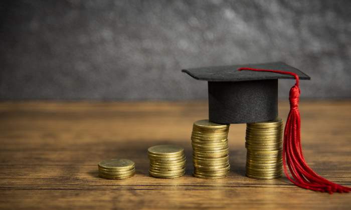 Un birrete sobre unas monedas transmite la idea de beca universitaria