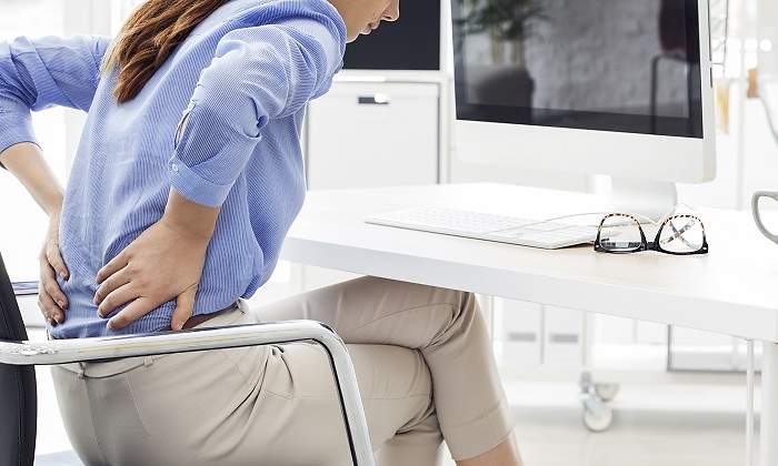 Mujer-sentada-con-dolor-en-la-espalda-iStock.jpg