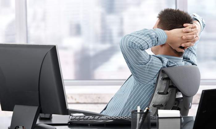 trabajador-descansa-ordenador-espaldas-dreamstime.jpg