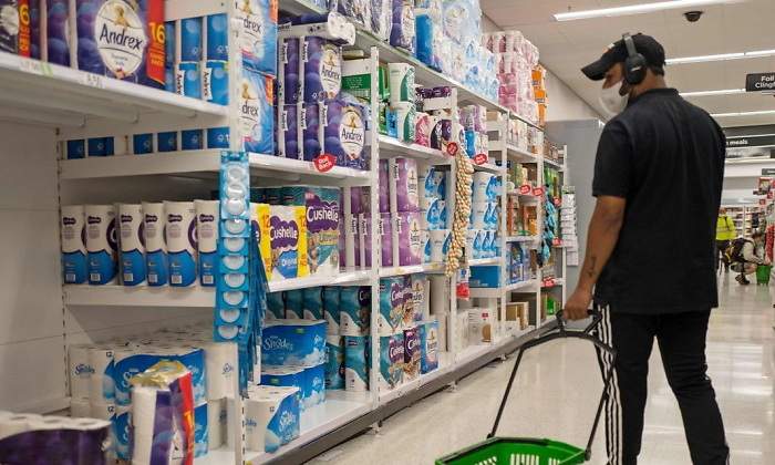 Un hombre con mascarilla hace la compra en un supermercado