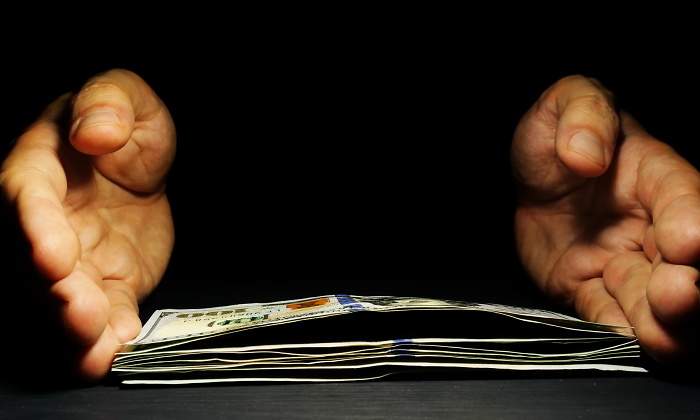 manos-dinero-oscuro-dreamstime.jpg