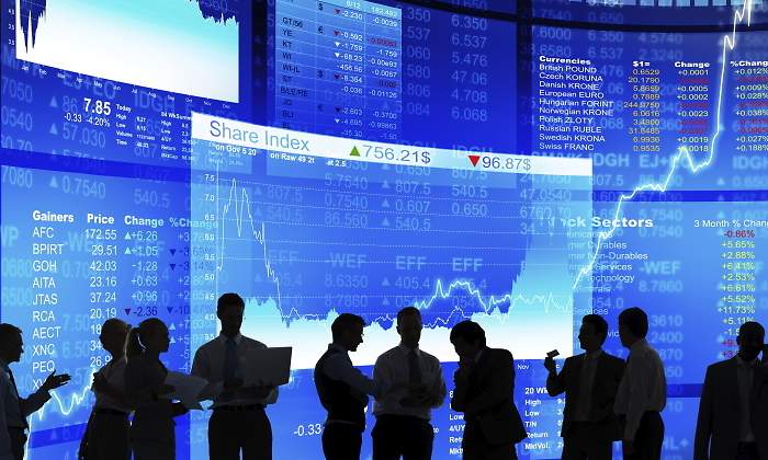 Varias personas que parecen inversores hablan sobre un fondo con grficas