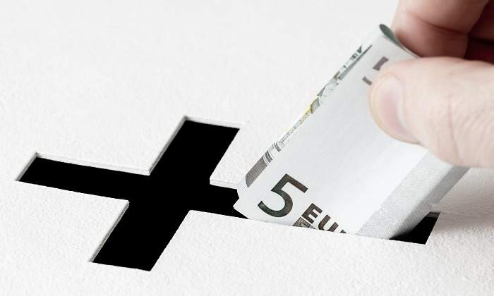 iglesia-donacion-euros-mano-dreamstime.jpg