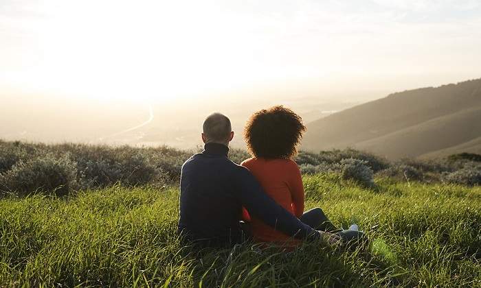 Pareja sentada en el campo iStock