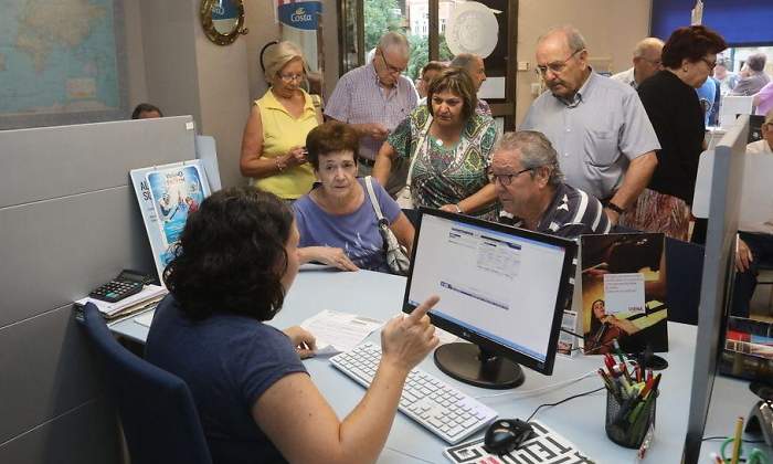Personas mayores son atendidas en una agencia de viajes