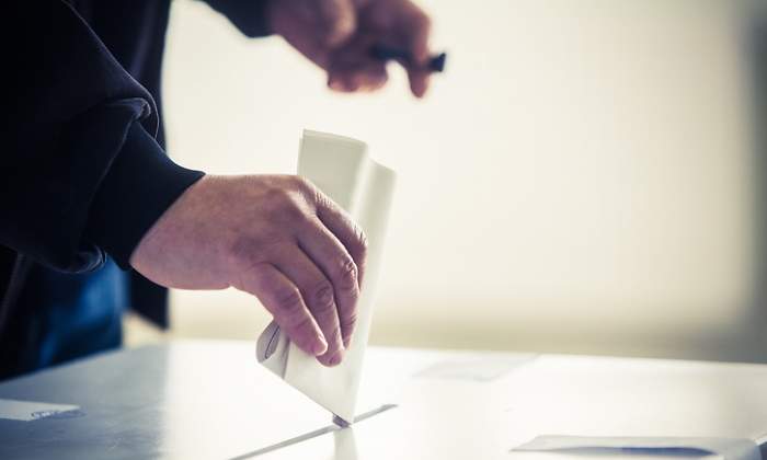 Alguien deposita un voto en una urna electoral