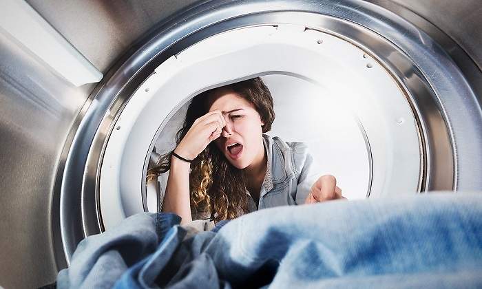 Mujer-sacando-ropa-que-huele-mal-de-la-lavadora-iStock.jpg