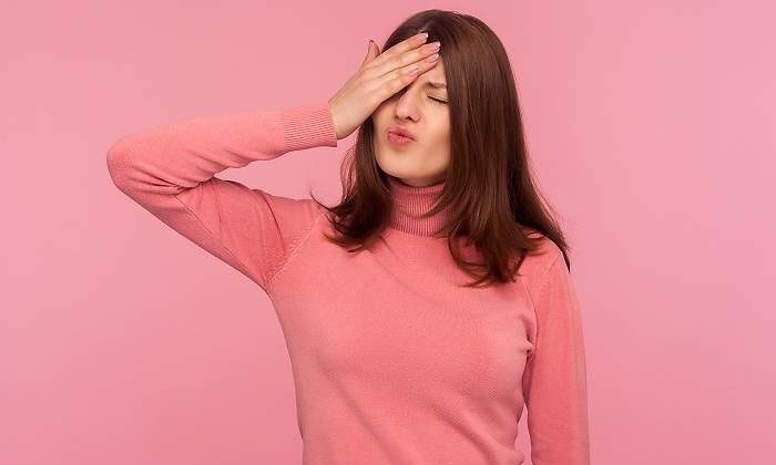 Una-chica-vestida-de-rosa-con-la-mano-en-la-frente-iStock.jpg