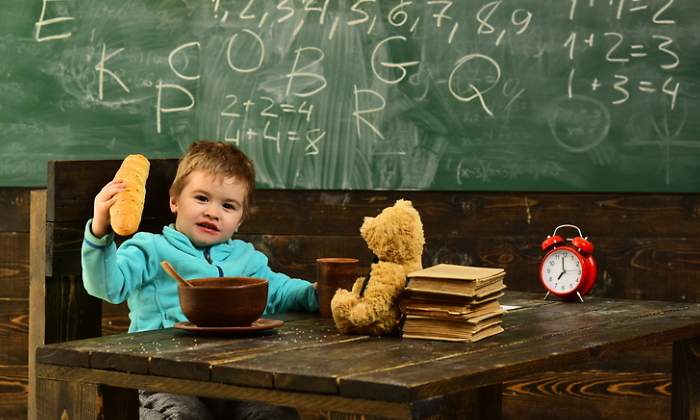 Un nio come en su pupitre en la escuela
