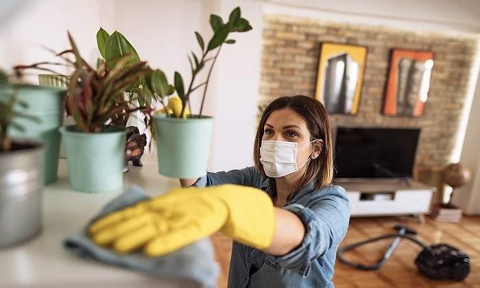 Un-mujer-con-mascarilla-limpiando-su-casa-iStock.jpg