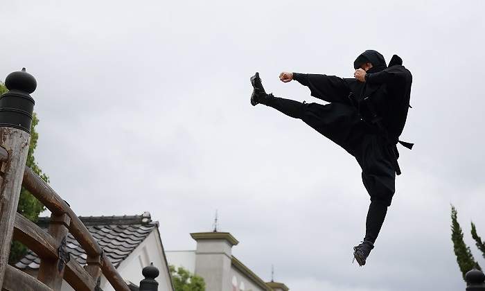 Un-ninja-vestido-de-negro-saltando-con-la-pierna-en-alto-iStock.jpg