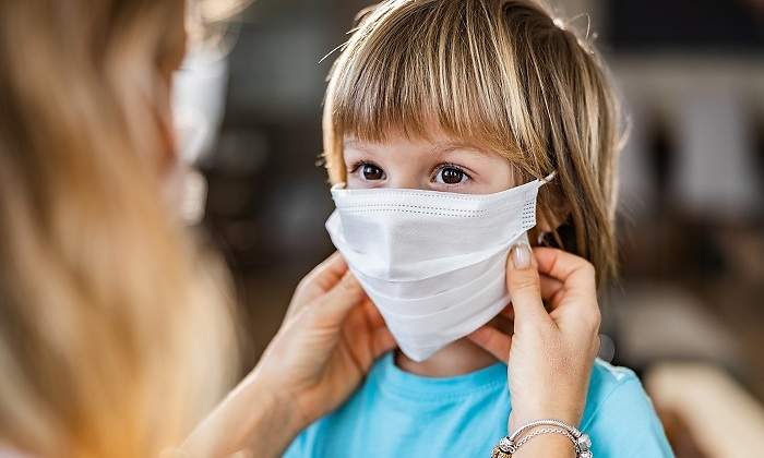 Mujer-colocandole-mascarilla-a-un-ninos-iStock.jpg