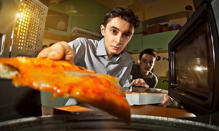 Una-persona-metiendo-un-trozo-de-comida--en-el-microondas-iStock.jpg