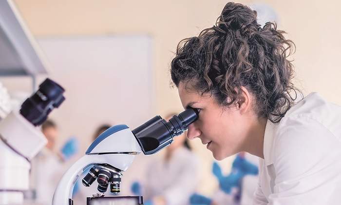 Una mujer trabaja en un laboratorio con un microscopio