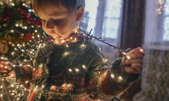 Un-nino-pequeno-jugando-con-las-luces-de-navidad-iStock.jpg