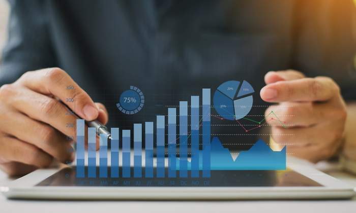 Un hombre examina unos grficos econmicos de realidad aumentada en su tableta