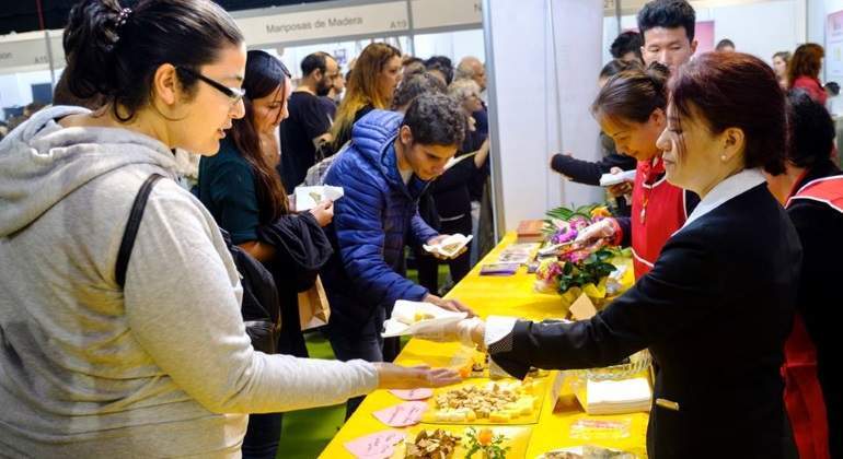 Personas probando comida de los expositores de la Veggie Word Madrid 2019.
