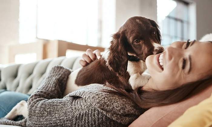 Chica-sonriente-jugando-con-su-perro-iStock.jpg