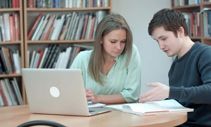 Dos estudiantes trabajan en la biblioteca