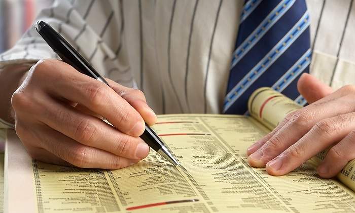 Una-persona-utilizando-las-paginas-amarillas-par-buscar-iStock.jpg