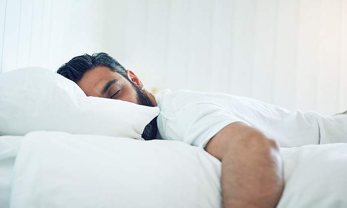 Un-hombre-durmiendo-boca-abajo-sobre-una-cama-iStock.jpg