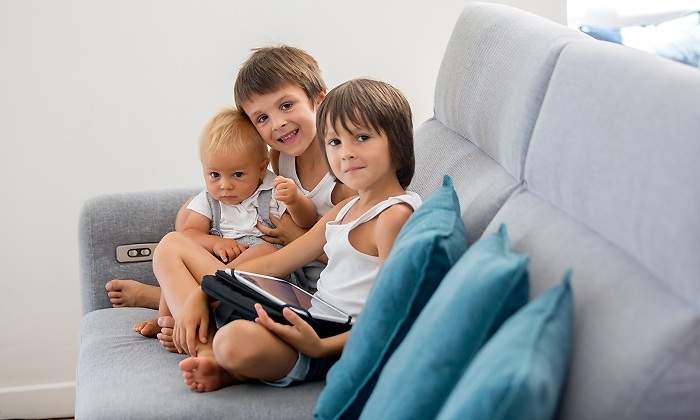 Tres-hemanos-sentados-en-un-sofa-gris-iStock.jpg