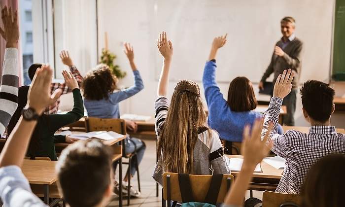 Clase-llena-de--alumnos-con-la-mano-levantada-iStock.jpg