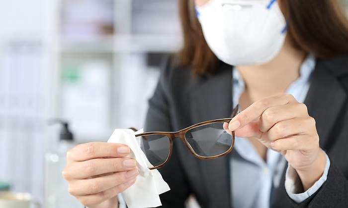 Una-mujer-con-traje-limpiando-sus-gafas-iStock.jpg